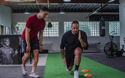 pexels-photo-5646004-5646004 Full body of focused man in sportswear doing stretching exercises with coach in contemporary fitness center