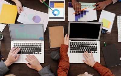 pexels-photo-6476258-6476258 Overhead view of a team discussing digital marketing strategies with laptops and charts.